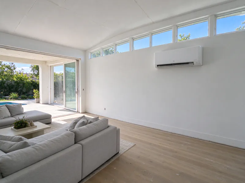 Family room addition with a vaulted ceiling and a white mini split head on the solid wall below clerestory windows