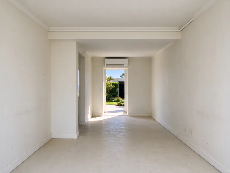 Paint-matched indoor line-hide running along the ceiling line of a condo hallway